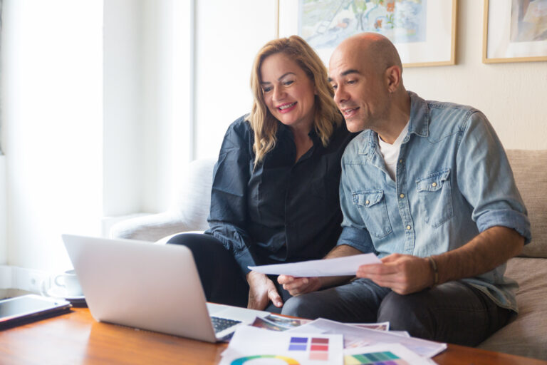Cheerful couple of clients consulting interior designer